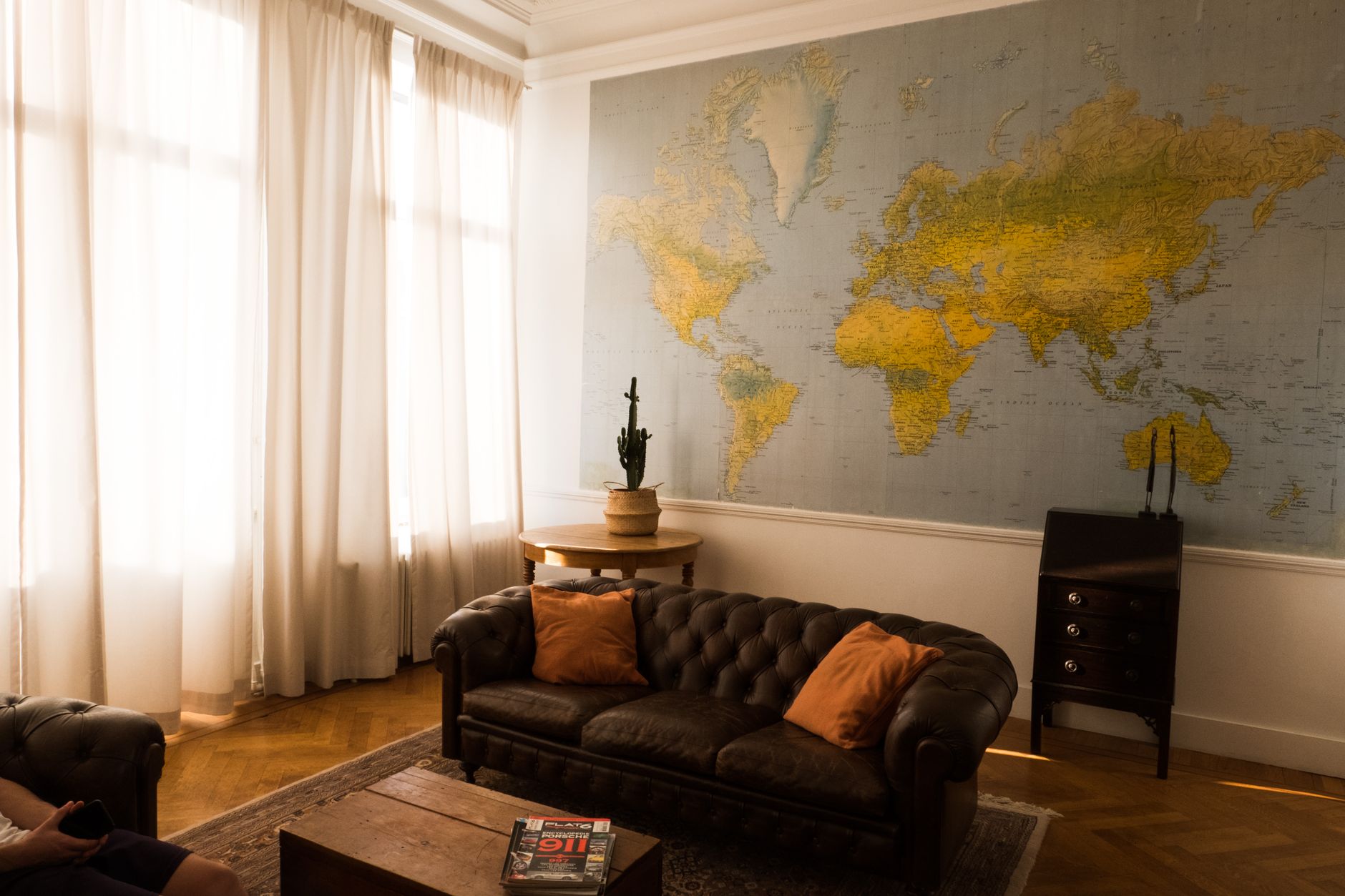 Elegant living room in Brussels featuring a world map wall decor and comfortable seating.