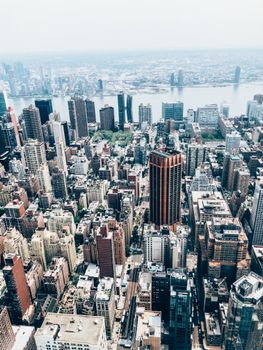 Scenery drone view of contemporary city with multistage residential buildings near river under endless sky in daylight