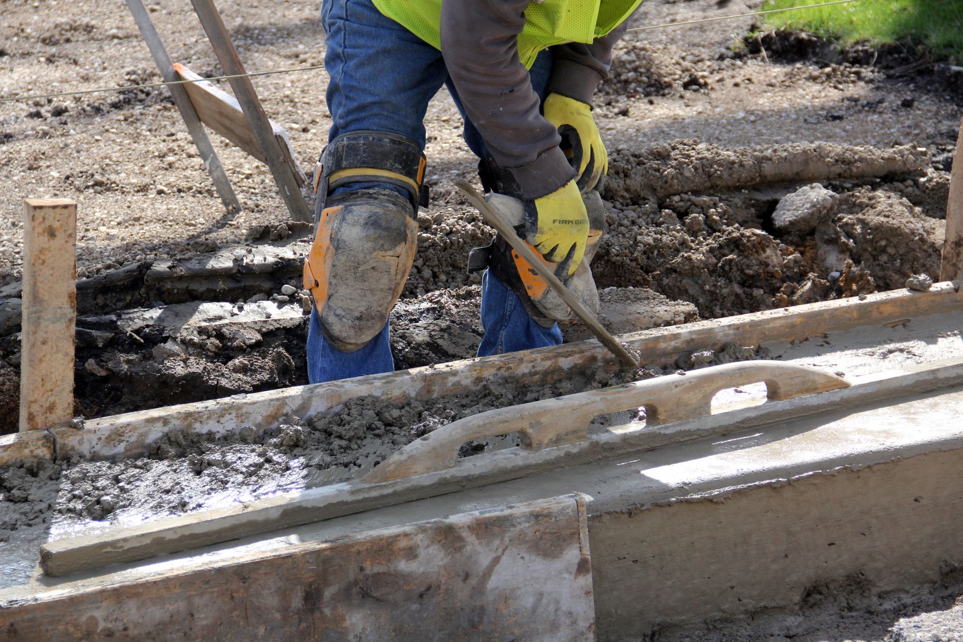 Asphalt driveway contractor in work gear finishing a professional repair and sealing job