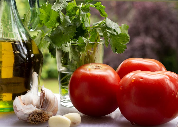 Tomatoes With Garlic Cloves Near Fresh Parsley And Oil