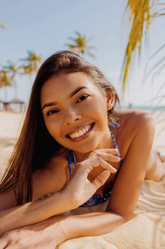 A woman smiling on a sunny beach. Perfect mood for a tropical getaway scene.