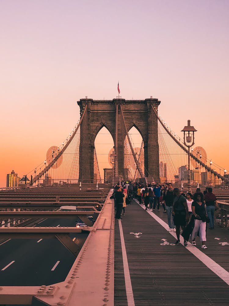 Busy People Walking On Brooklyn Bridge During Golden Hour