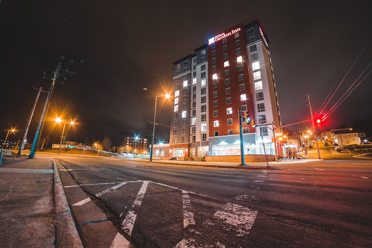 Roadway Near Modern Building And Glowing Street Lights At Night