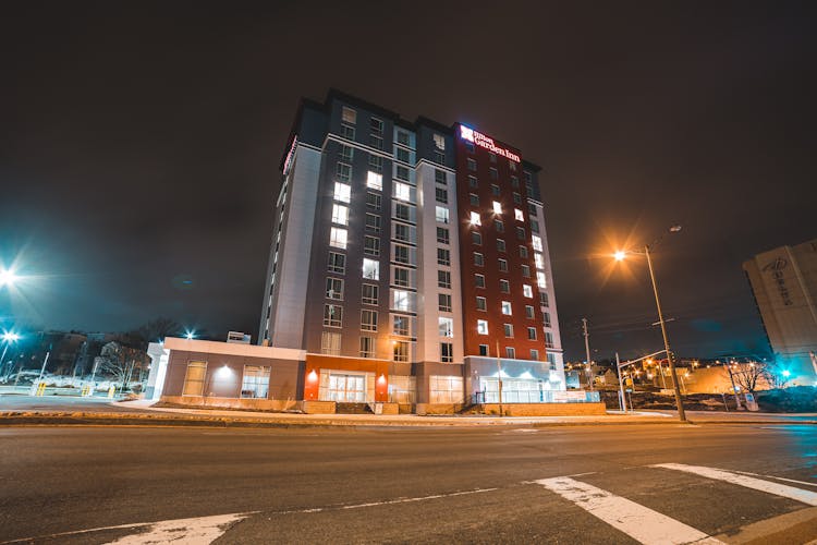 Bright Street Lamps Illuminating Modern Building And Road In Evening