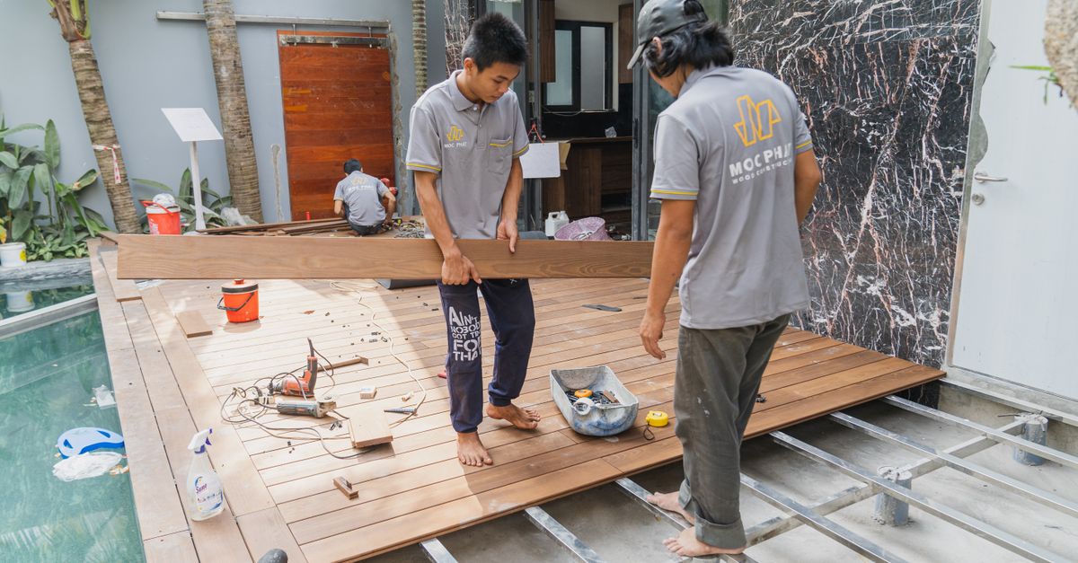 Carpenters working on a wooden floor installation in Hồ Chí Minh, Việt Nam.