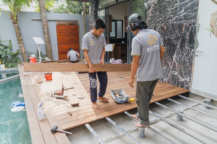 Workers Constructing The Wooden Floor Of A House