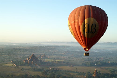 Hot Air Balloon Flying Over Temple and Landscape