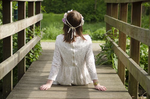 Free Woman Sitting on Brown Wooden Bridge Stock Photo