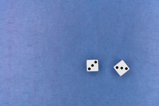 Overhead view of two dice on a blue textured surface, great for games or chance themes.