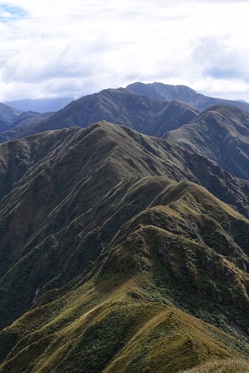 Spectacular landscape of majestic high mountain range with steep slope rough peaks against cloudy sky