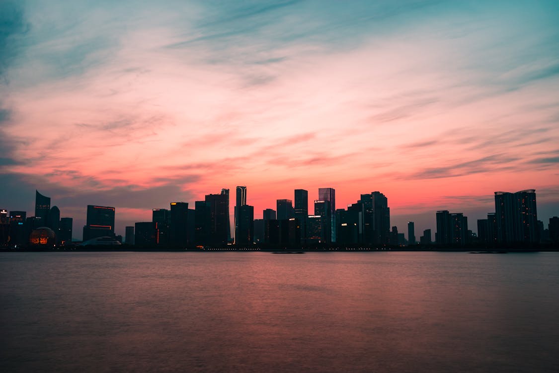 Picturesque sunset over skyscrapers and river · Free Stock Photo