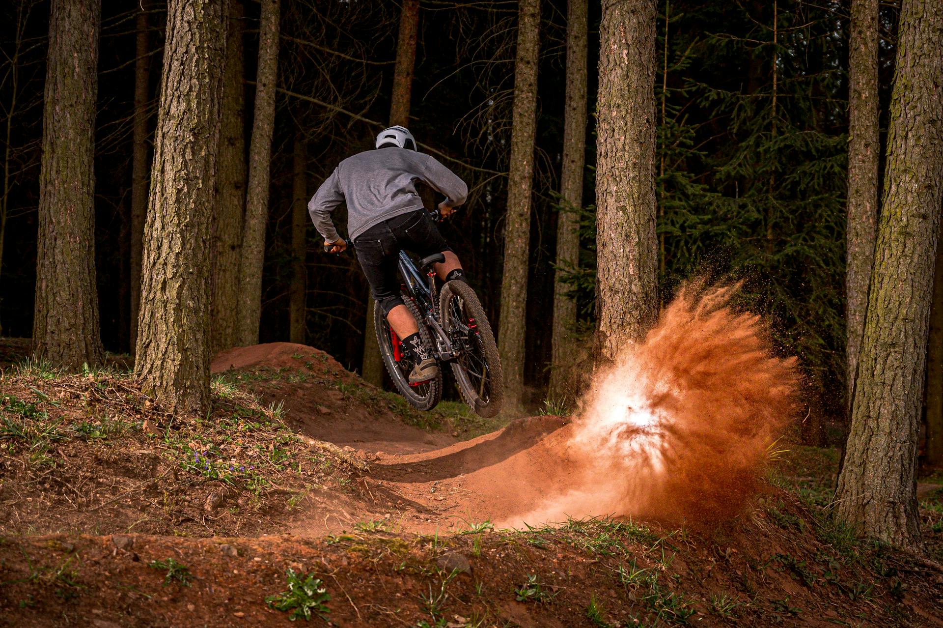 Action-packed mountain biking in Trutnov forest, capturing a rider's thrilling dirt trail maneuver.