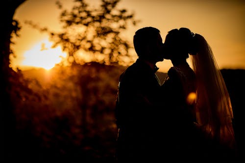 Silhouette of Couple Kissing during Sunset