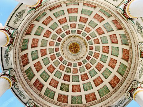 Ornamental ceiling of aged colonnade on sunny day