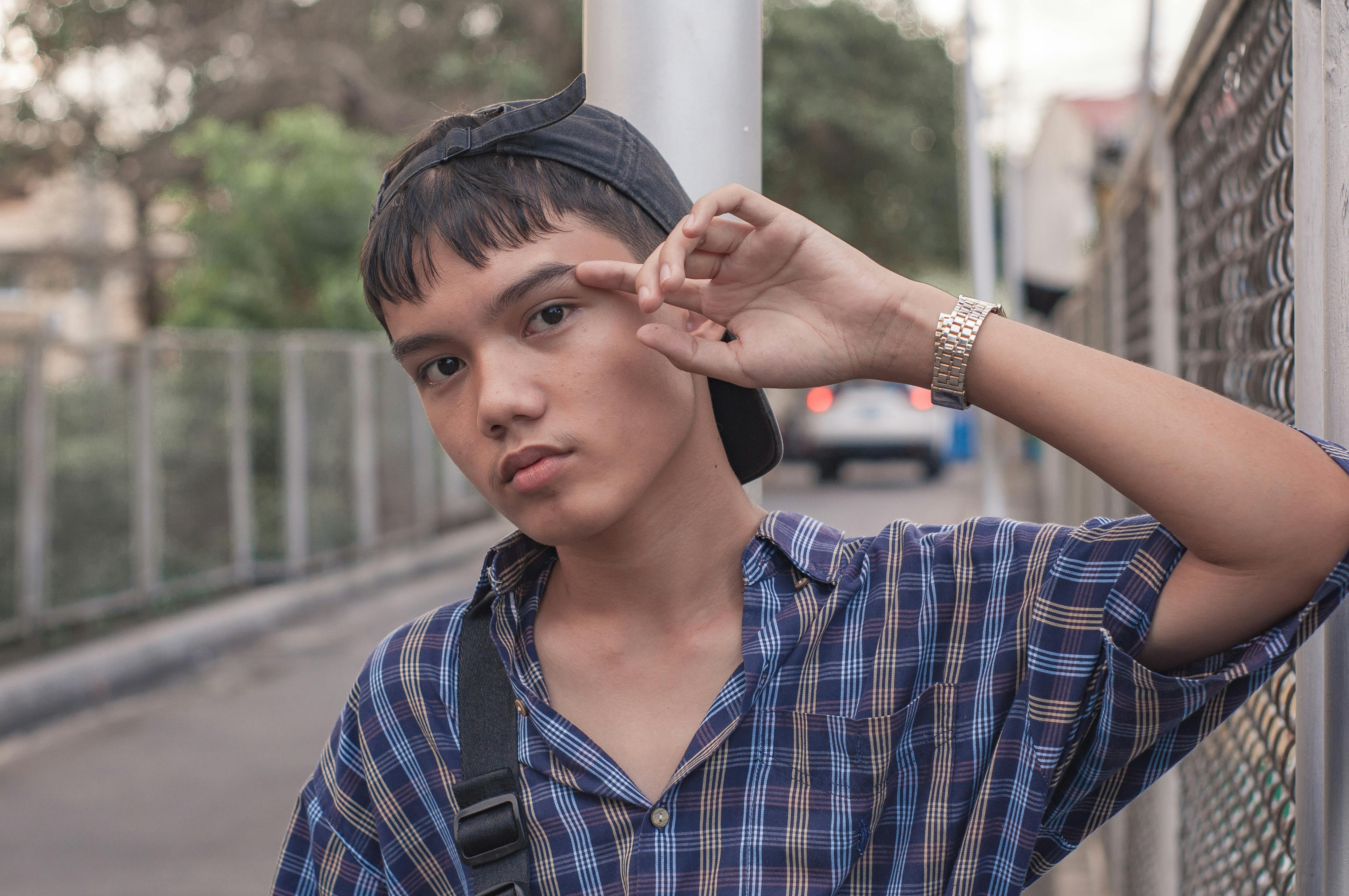 pensive young ethnic man resting on city street