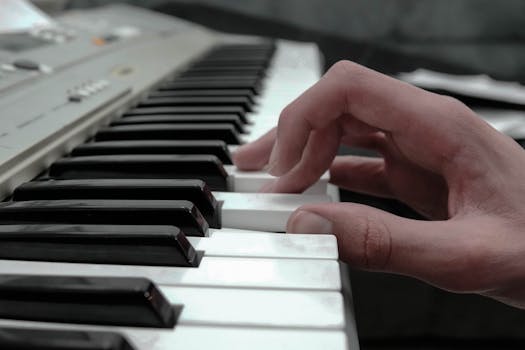 A close-up view of a hand gracefully playing piano keys with selective focus.