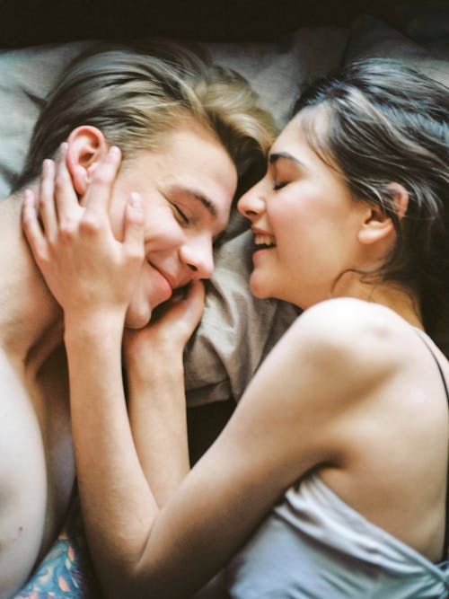 бесплатная Мужчина и женщина, лежащие на кровати Стоковое фото