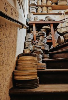 Vintage stacked film reels on a wooden staircase in Prague, Czechia.
