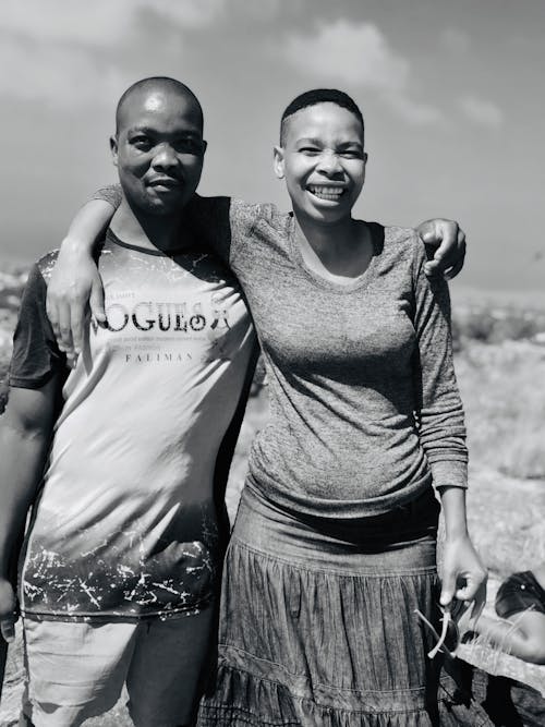 Carefree black couple hugging in nature