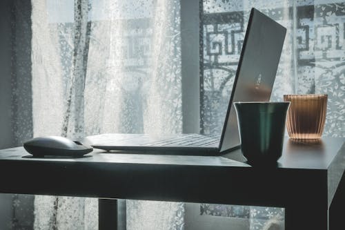 Free Laptop and wireless mouse on desk Stock Photo