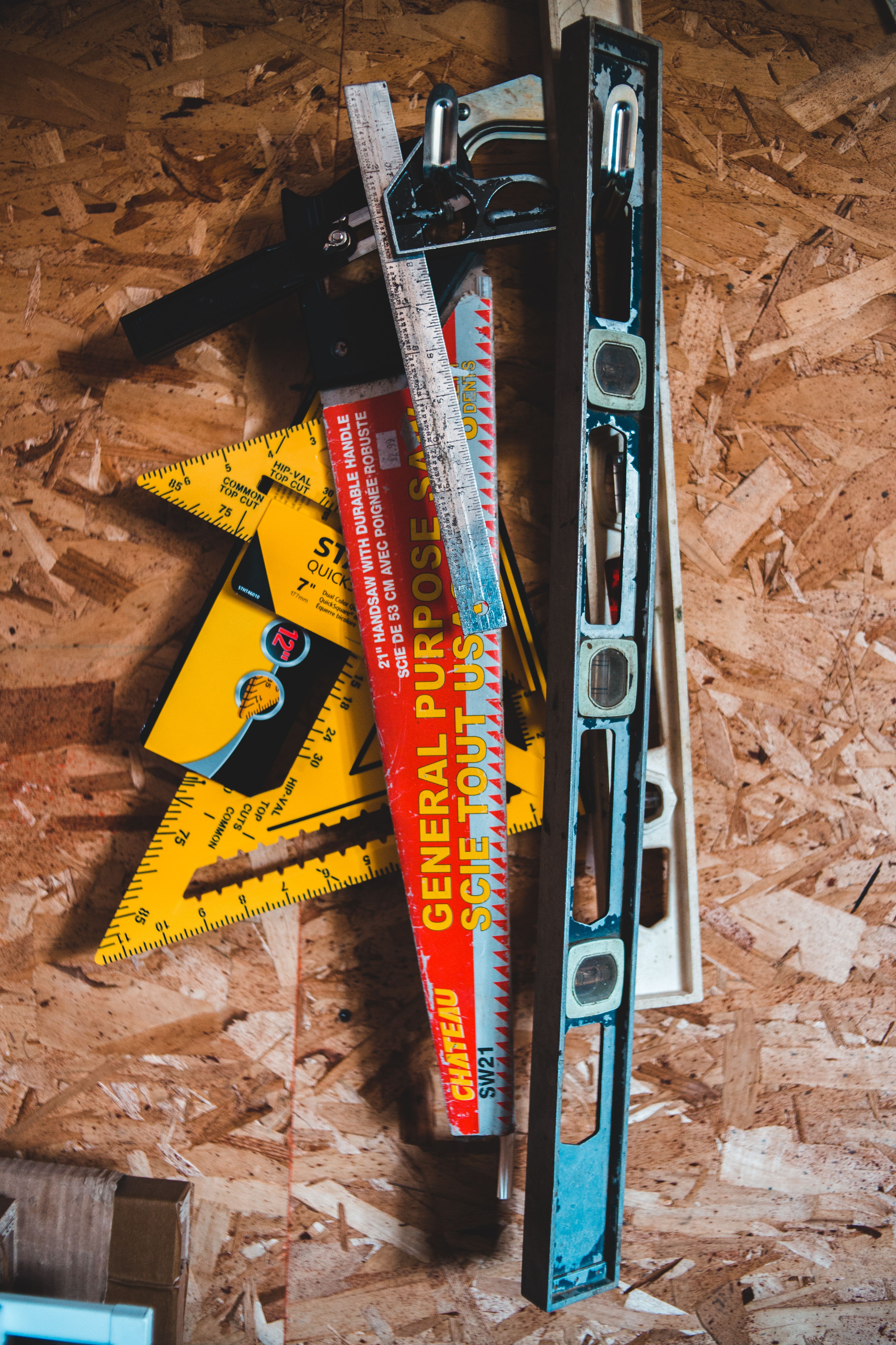 A collection of tools used for creating a reverse library, including a ruler, level, pencil, eraser, and measuring tape.