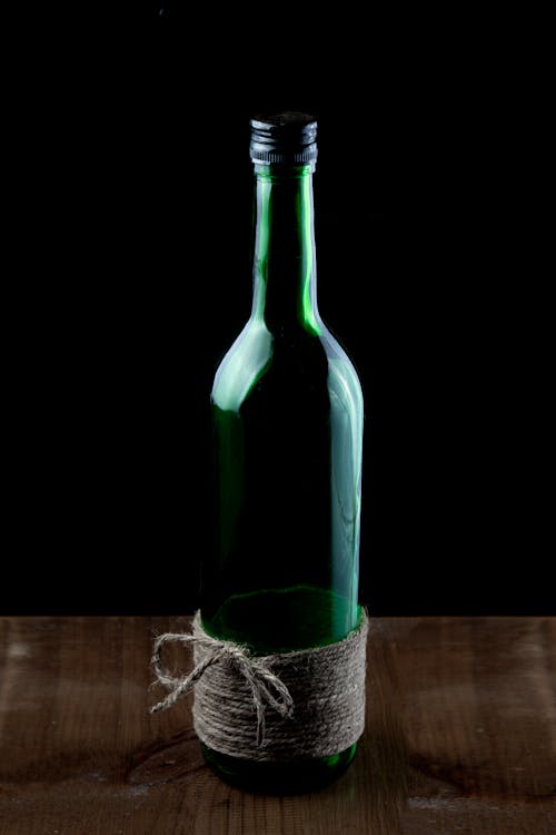 Empty glass bottle decorated with hemp rope