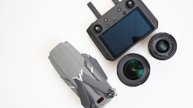 Top view of a drone, controller, and camera lenses on a white background.