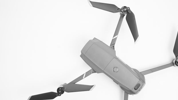 Aerial drone with propellers on a white surface, showcasing modern technology.