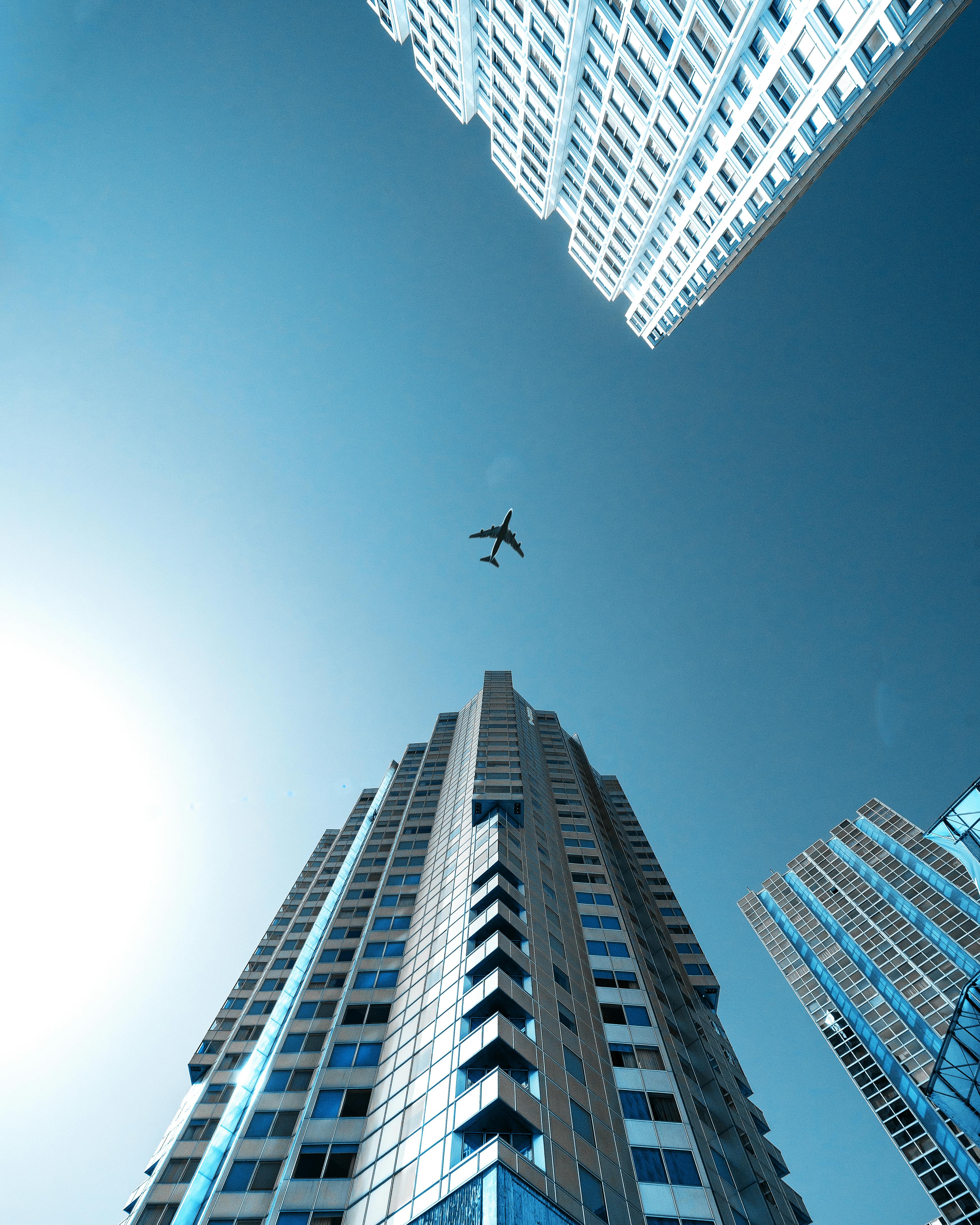A dramatic view of skyscrapers in Paris with an airplane flying overhead on a clear day.