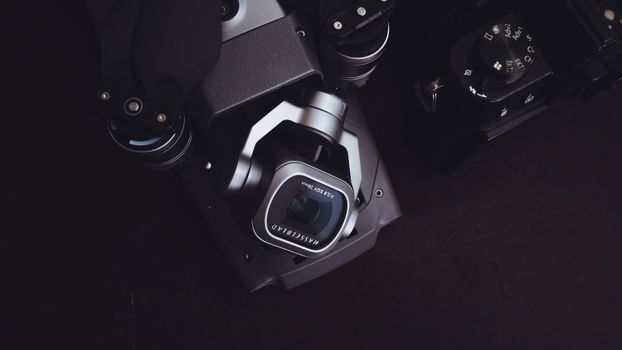 From above contemporary professional photo camera and equipment placed on black table