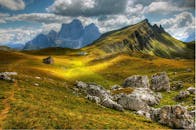 在多云的天空下，探索连绵起伏的丘陵、雄伟的山脉和令人惊叹的高山景观