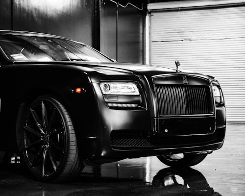 Hood of elegant luxury black car parked on marble floor in modern building garage