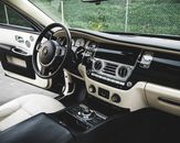 Expensive luxury car interior with white leather seats and shiny dashboard