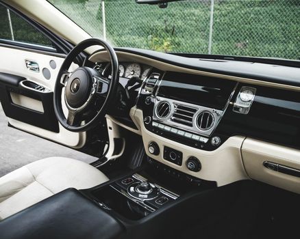 Expensive luxury car interior with white leather seats and shiny dashboard
