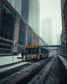 冬季，一辆城市巴士行驶在明尼阿波利斯市中心白雪皑皑的街道上，展现着城市生活的景象