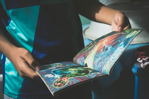 Free Crop child reading comics at home Stock Photo