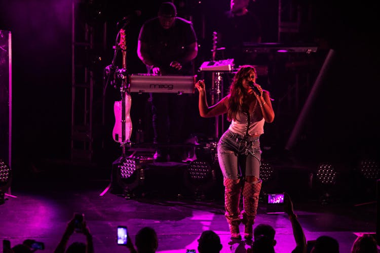 Young Female Singer Performing Show On Stage With Neon Lights