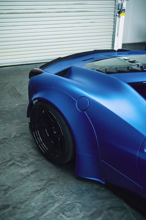 High angle of tire and back window of fashioned expensive blue coupe car parked in garage