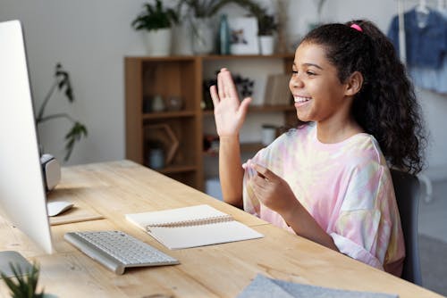 Free Woman in Pink Shirt Sitting by the Table While Smiling Stock Photo