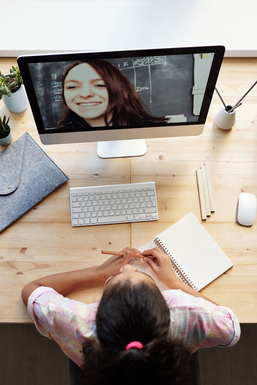 A student following along on screen with a notebook open, taking notes during class