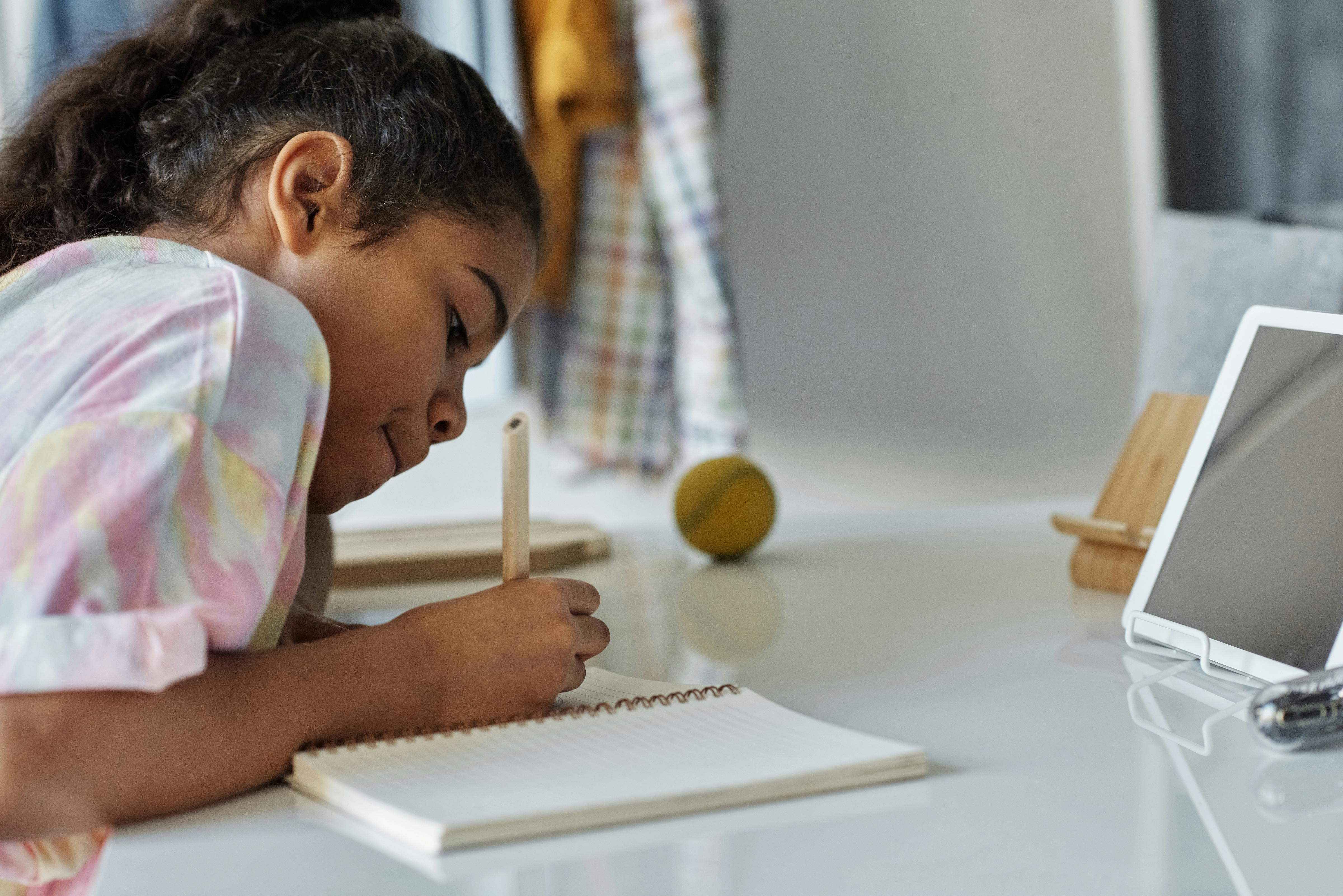 photo of girl writing on white paper