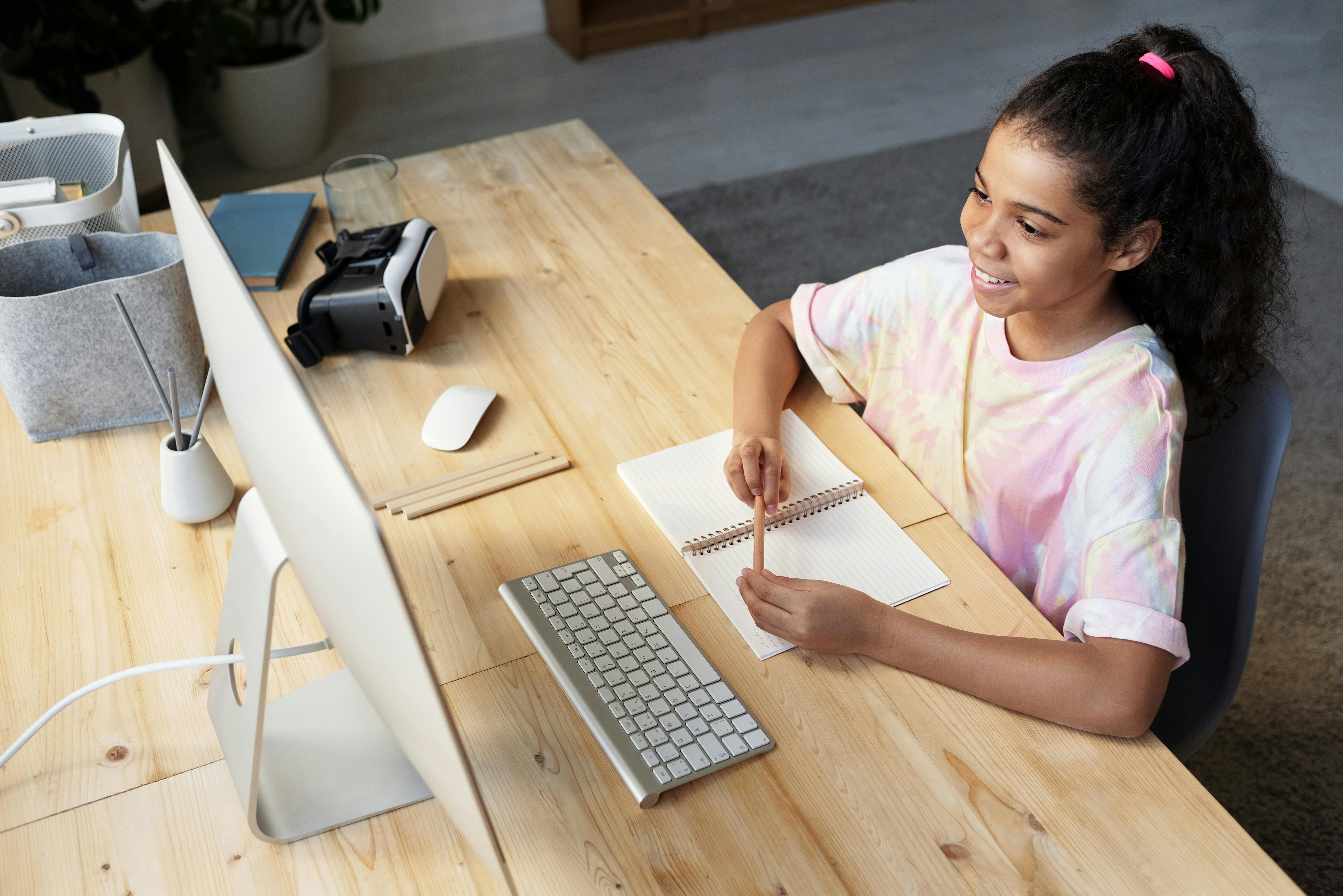 girl in pink t shirt looking at the imac