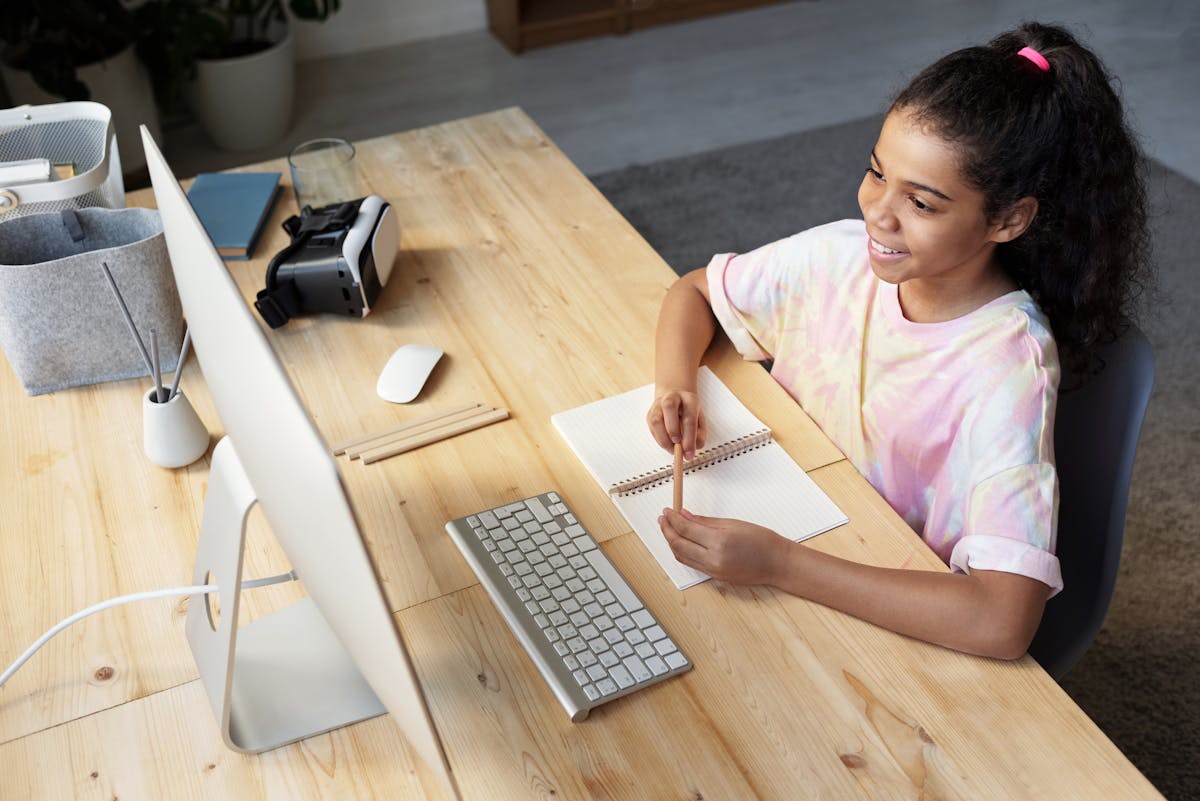 Student using a tablet with stylus and headphones while studying