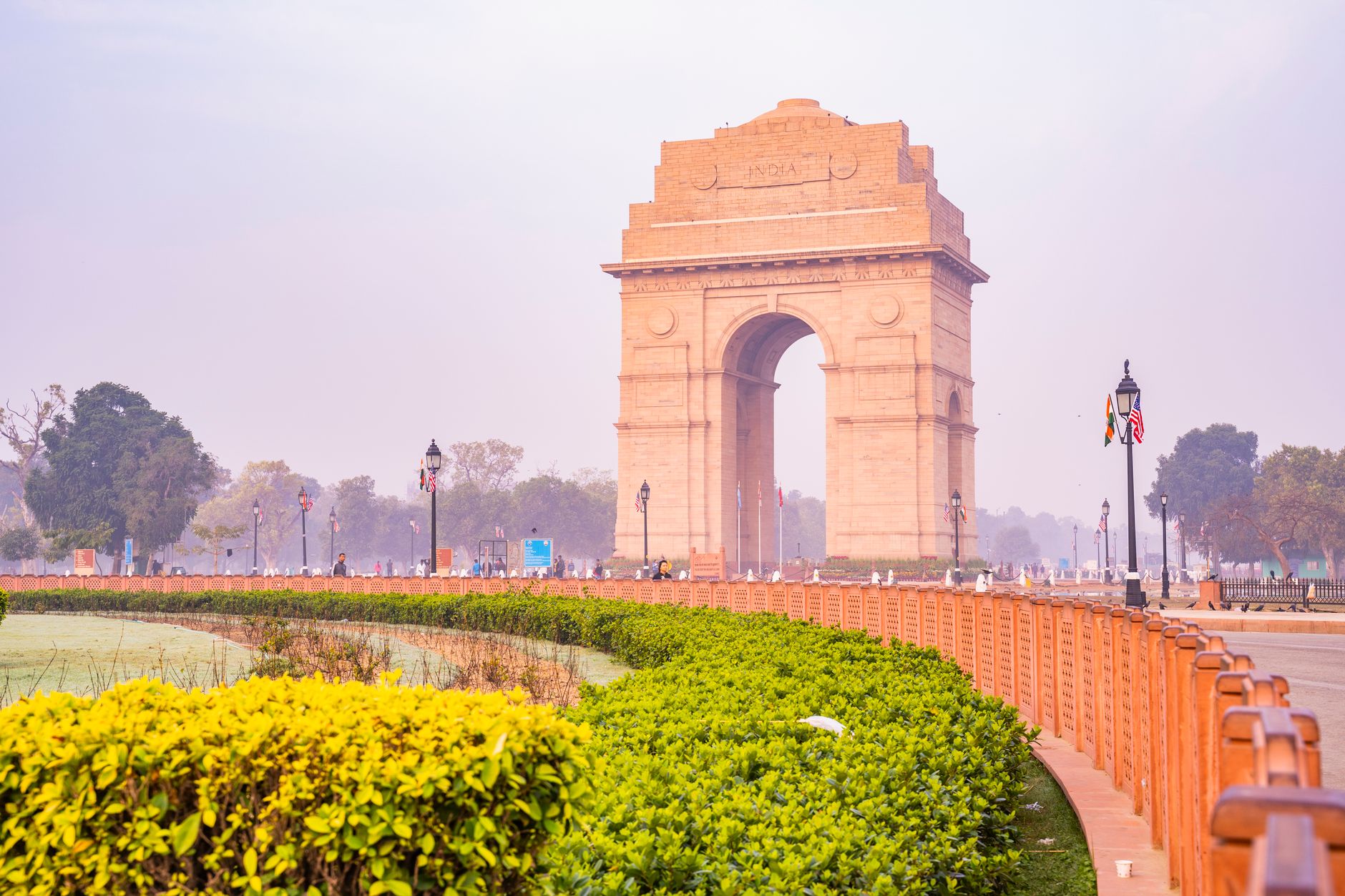 A vibrant capture of the iconic India Gate in New Delhi, surrounded by lush gardens on a sunny day, showcasing its architectural brilliance.
