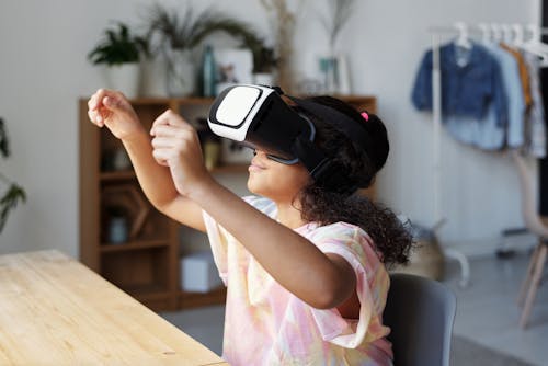 Girl in Pink Shirt Wearing Black and White Vr Headset