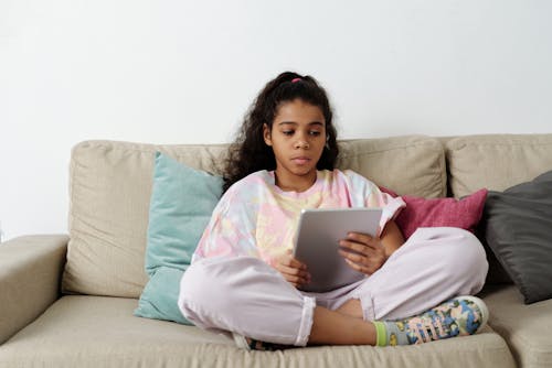 Free Girl in Pink Shirt Sitting on Couch Stock Photo
