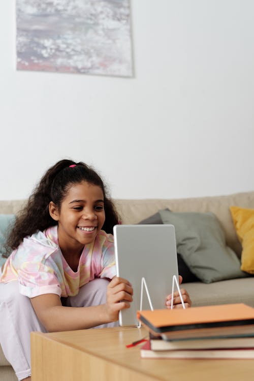 Free Photo of Girl Smiling While Holding Tablet Computer Stock Photo