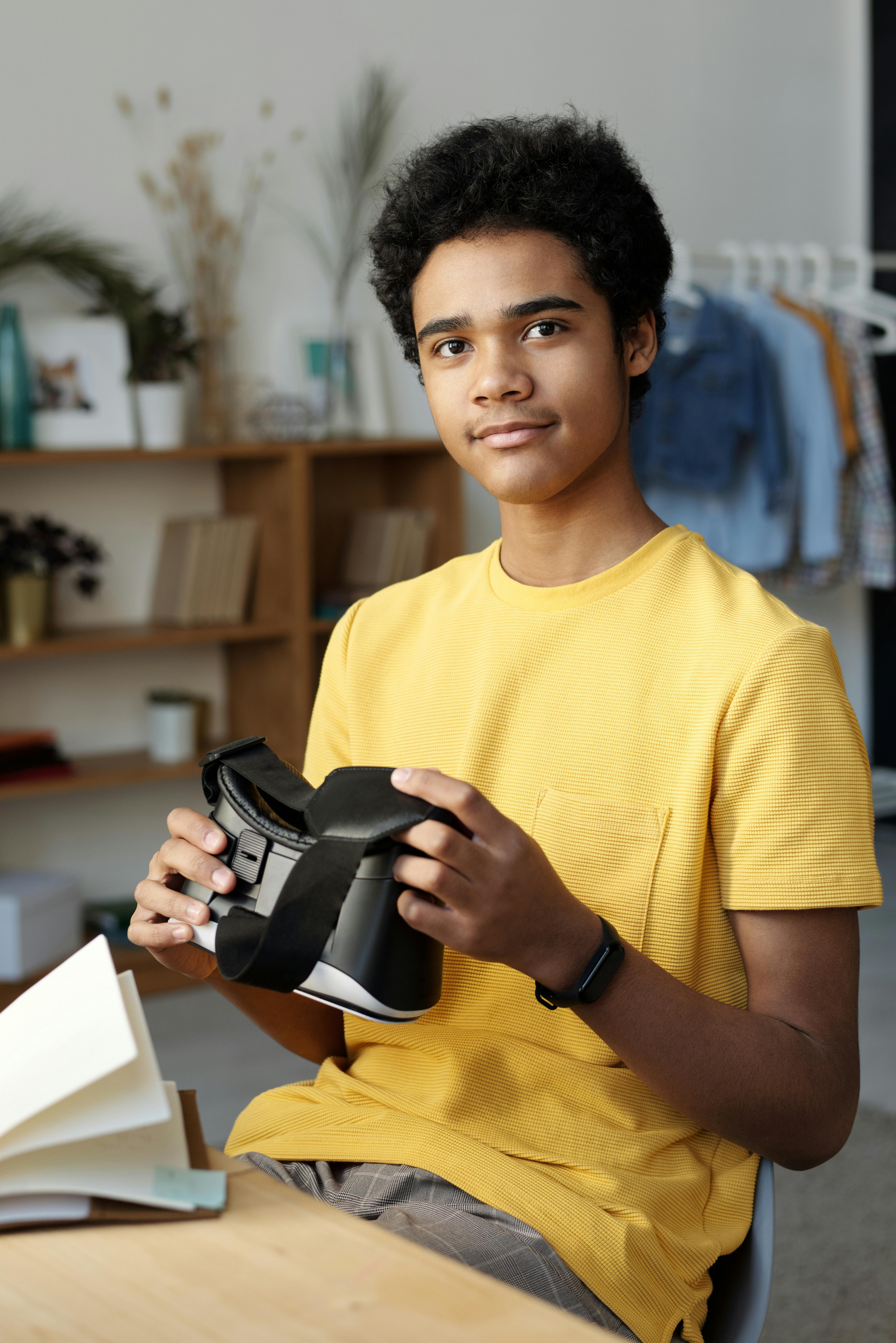 photo of boy smiling while holding vr headset