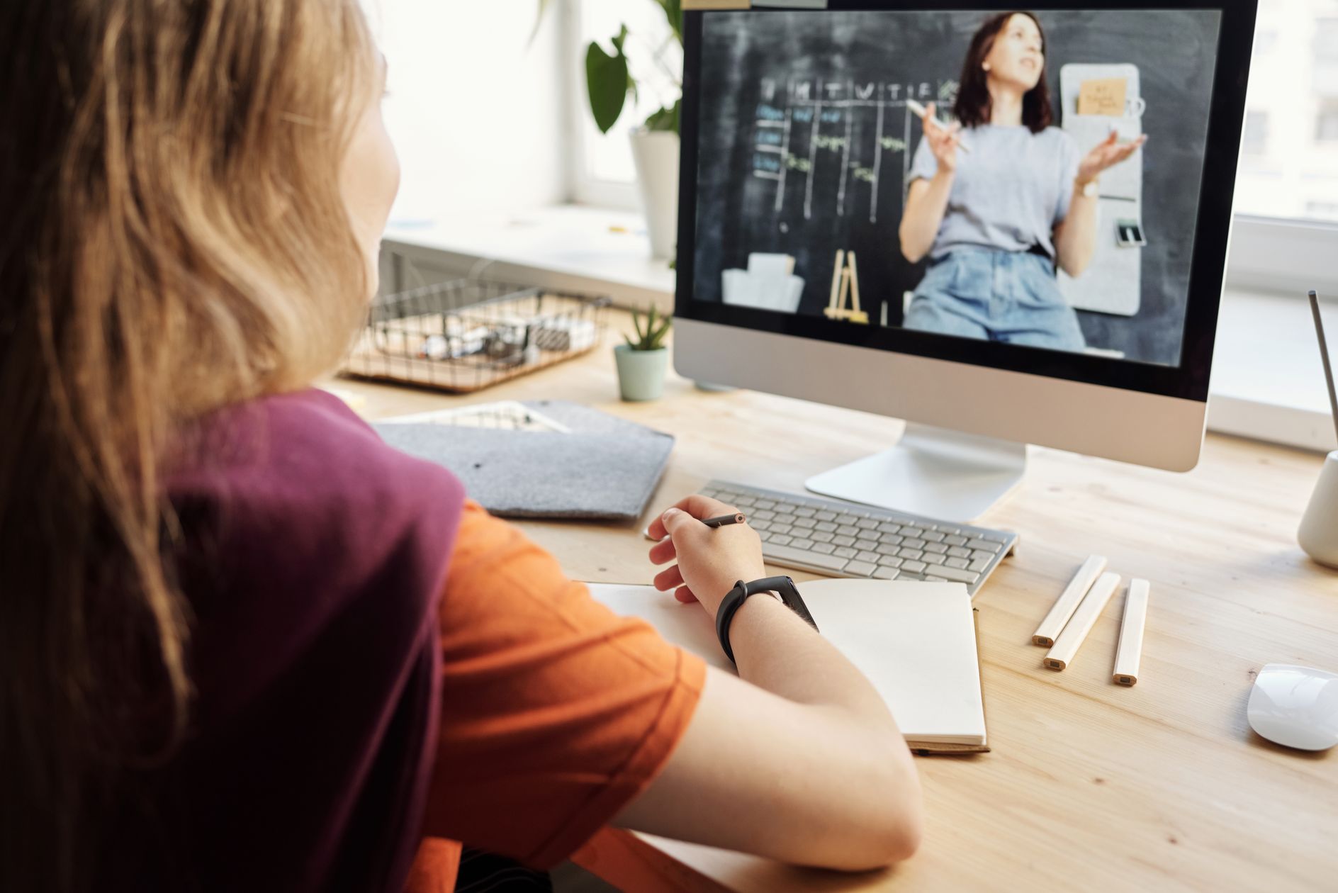 Online learner taking notes beside laptop for micro credential career growth in 2026