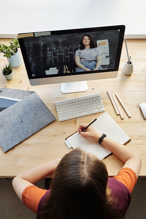 Free Top View Photo of Girl Watching Video Through Imac Stock Photo